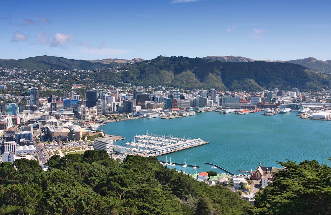 Wellington City skyline and the golden sand beach of Oriental Bay nestled along the blue waters of Wellington Harbour.